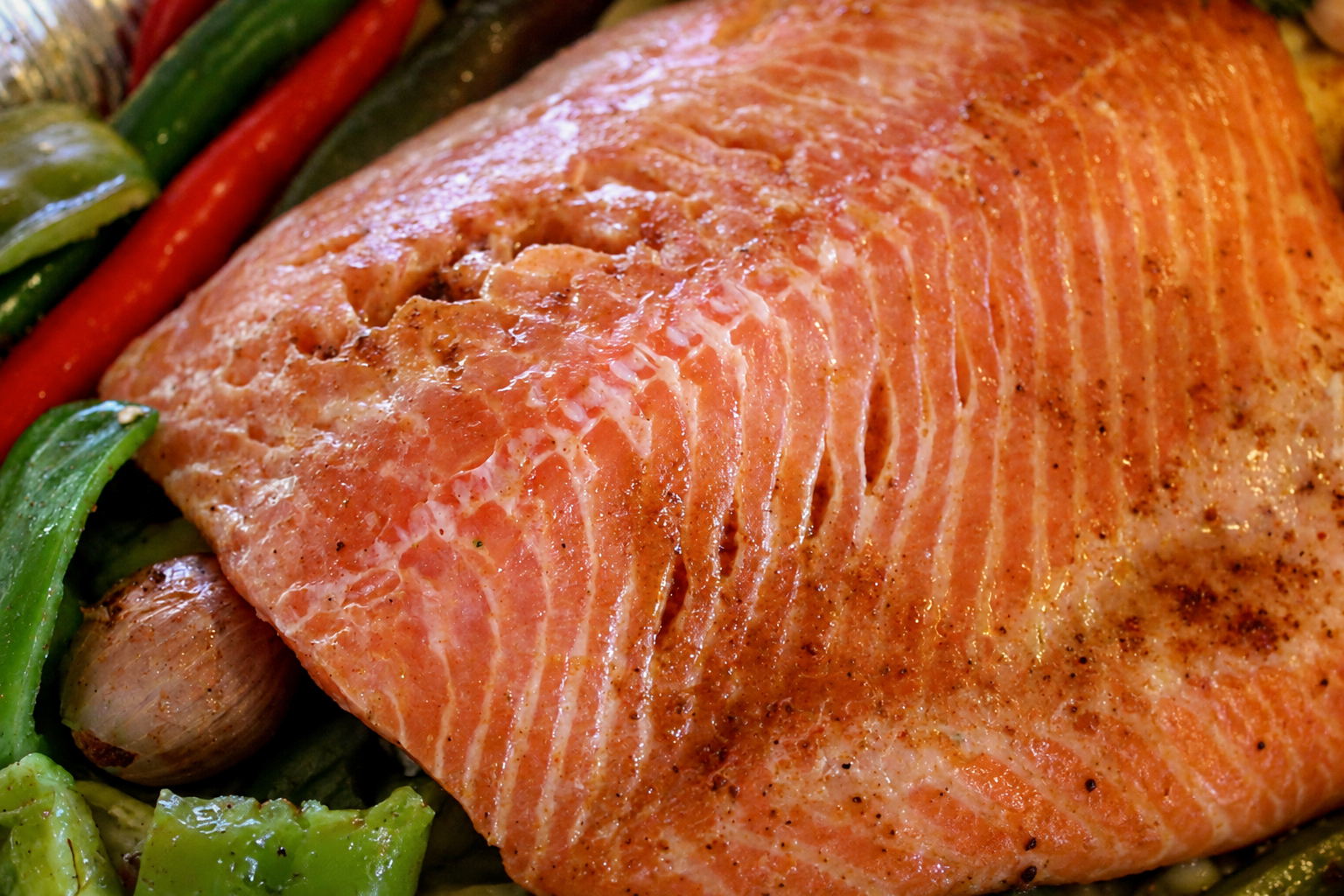 A salmon fillet served with grilled peppers